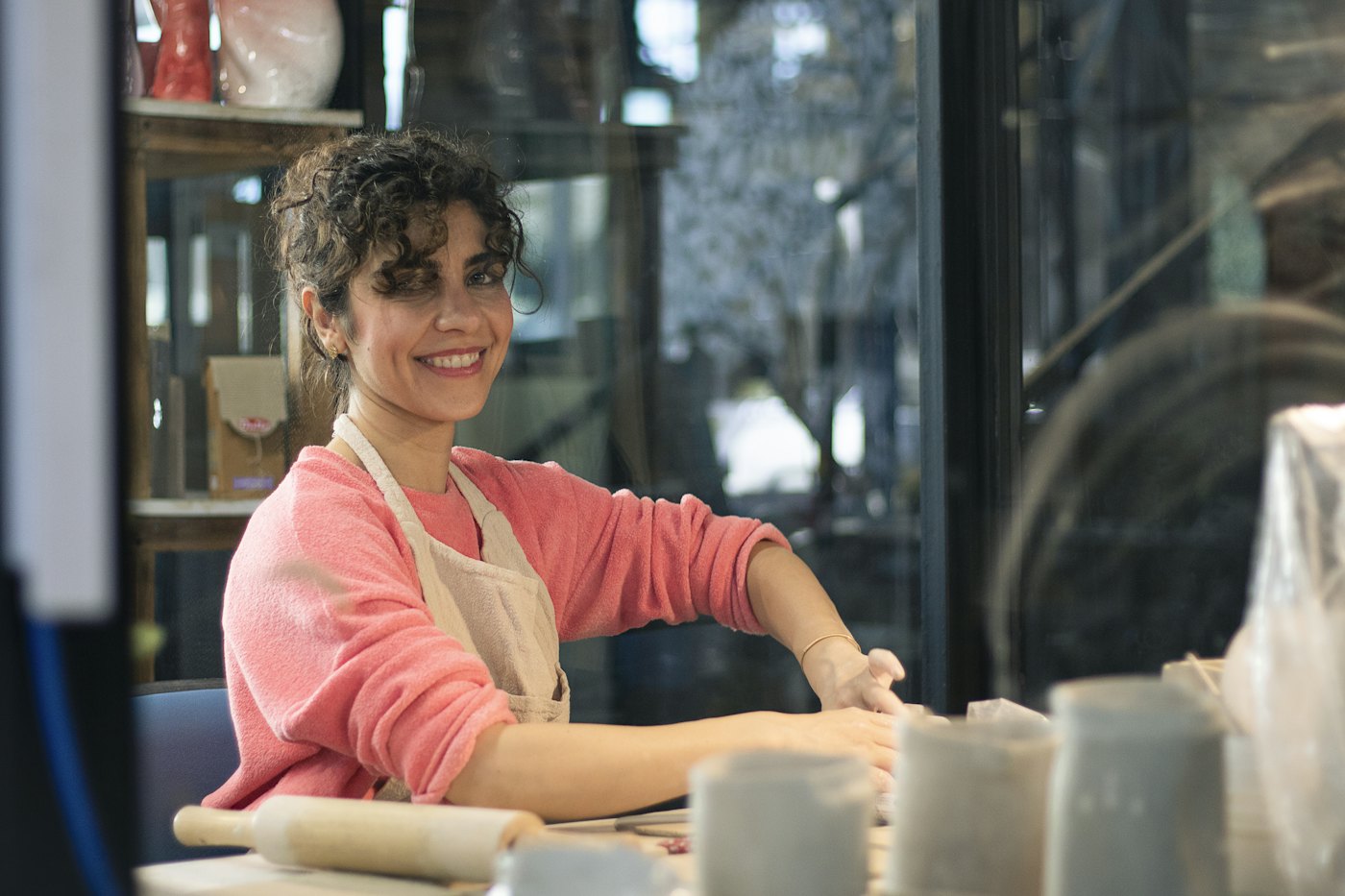 Zuzana, smiling at her workbench in the pottery studio